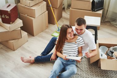 Belge okunuyor. Yeni dairelerinde neşeli genç bir çift. Taşınma kavramı.