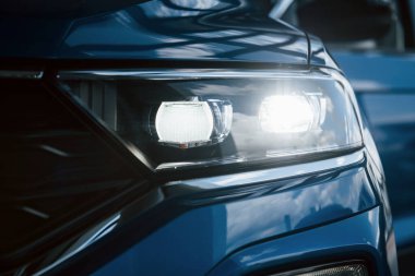 Yepyeni modern mavi arabanın ön tarafı. Galeriye park ettim. Farlardaki yansıma..