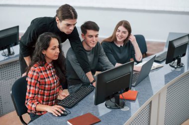 Bir plana göre. Modern ofiste çalışan günlük kıyafetli bir grup genç..