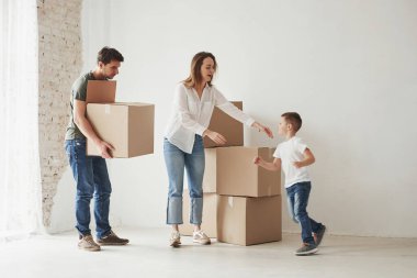 Koşan çocuk. Aile yeni eve taşınıyor. Taşınan kutular açılıyor.