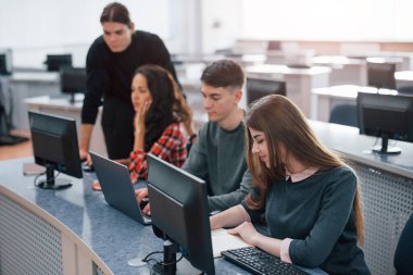 Geniş bir alan. Modern ofiste çalışan günlük kıyafetli bir grup genç..