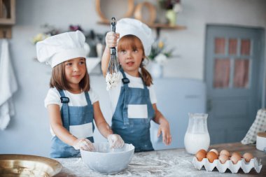 Beyaz şef üniformalı aile çocukları mutfakta yemek hazırlıyorlar..