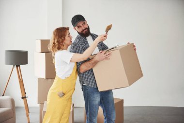 Sarı renkli üniforma. Yeni evlerinde birlikte mutlu bir çift. Taşınma kavramı.