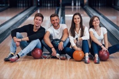 Harcamak için iyi zaman. Genç neşeli arkadaşlar hafta sonları bowling kulübünde eğleniyorlar..