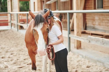 Çiftlikte birlikte. Gündüz vakti atıyla çiftlikte mutlu bir kadın.