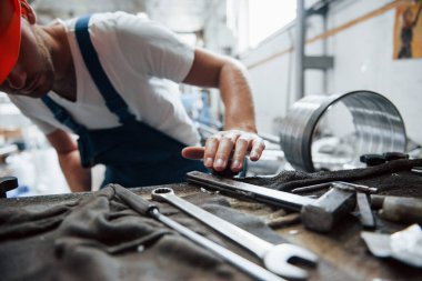 Aletler masada. Üniformalı adam prodüksiyonda çalışıyor. Endüstriyel modern teknoloji.