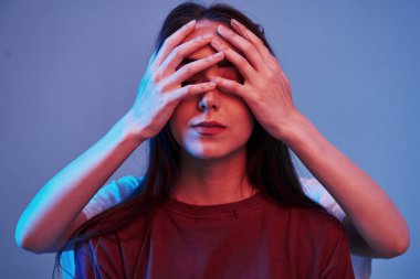 Kız kardeş gözleri kapatır. Stüdyo içeride neon ışıkla çekiliyor. İki güzel ikizin fotoğrafı..