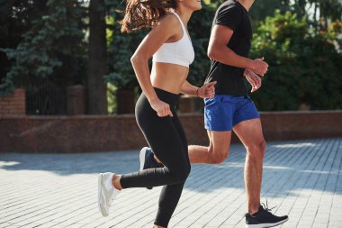 Erkek ve kadının spor günleri var ve şehirde gündüz koşuyorlar..