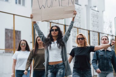 Beyaz ırk kökenli. Bir grup feminist kadın dışarıda hakları için protesto yapıyor..