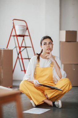 Düşünceli bir bakış. Beyaz duvarları ve pencereden gelen gün ışığıyla odada genç bir esmer..