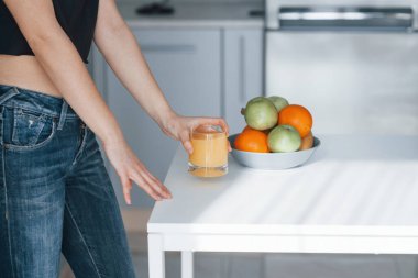 Kesilmiş fotoğraf. Günümüz mutfağında hafta sonları evde olan bir kız..