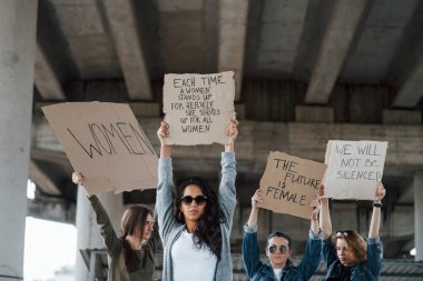 Bulutlu hava. Bir grup feminist kadın dışarıda hakları için protesto yapıyor..