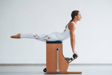 Omurga egzersizi. Zayıf vücutlu, kendine güvenen, genç, sportif bir kadın..