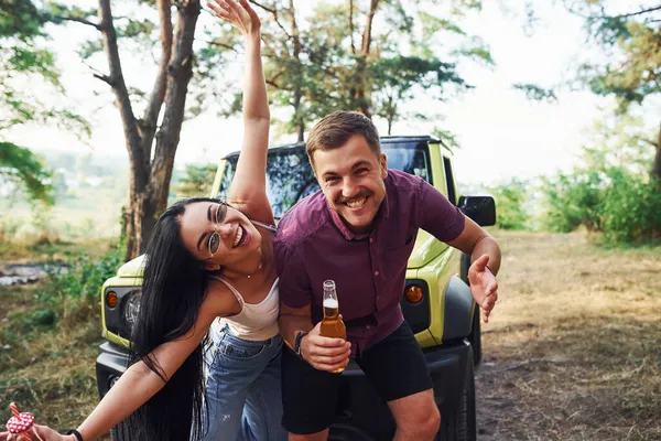 Sonriendo Divirtiéndose Par Jóvenes Con Alcohol Divierten Bosque Jeep Verde — Foto de Stock