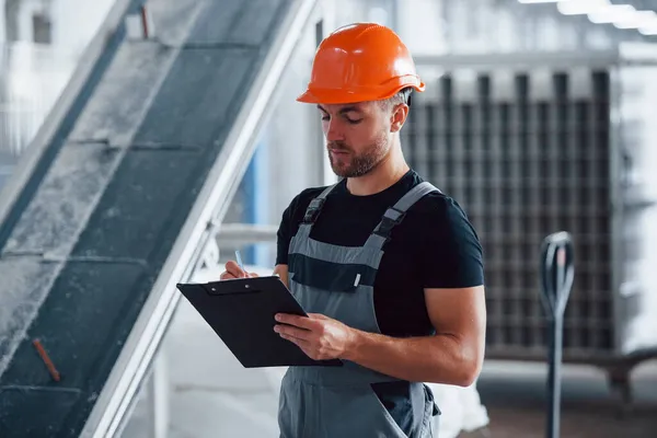 Soustředěný Práci Zaměstnanec Uvnitř Továrně Mladý Technik Oranžovým Tvrdým Kloboukem — Stock fotografie