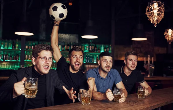 用足球 这是一个目标 庆祝胜利 三个体育爱好者在酒吧观看足球 手里拿着啤酒 — 图库照片
