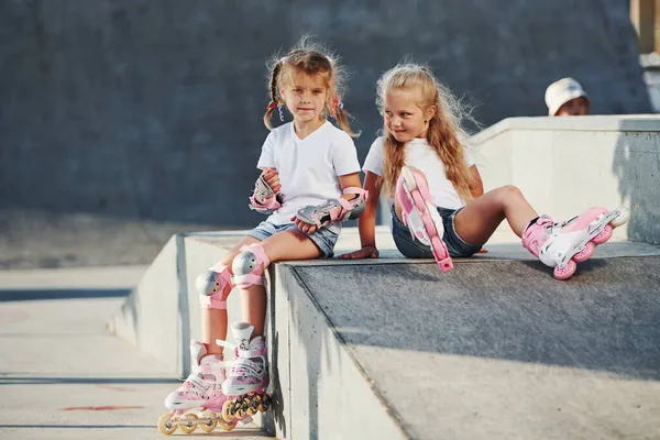 極端なスポーツのためのランプで ローラースケートを持つ2人の女の子屋外で楽しいです — ストック写真