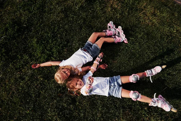 最上階だ 自由を感じる 夏に緑の芝生に寝そべっている2人の女性の子供 — ストック写真