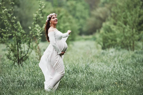 目を閉じて ドレスを着た美しい妊婦は屋外で散歩をしています ポジティブブルネット — ストック写真