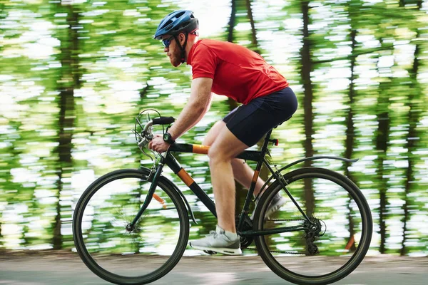 这就是健康的生活方式 骑自行车的人在森林里的柏油路上 — 图库照片