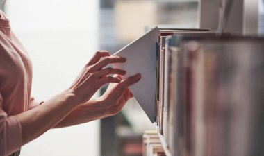 Şu beyaz olana ihtiyacım var. Kitaplarla dolu kütüphanede bilgi arayan bir kız..