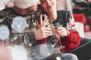 Birbirinize sevgiyle bakın. Mutlu gençler yılbaşı süslemeleriyle odada oturuyorlar..