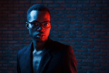 Göz giysisiyle. Fütürist neon ışıkları. Stüdyodaki Afrikalı Amerikalı genç adam..