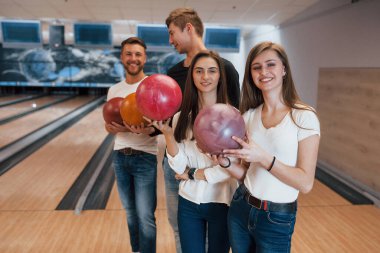 Birbirleriyle konuşan adamlar. Genç neşeli arkadaşlar hafta sonları bowling kulübünde eğleniyorlar..