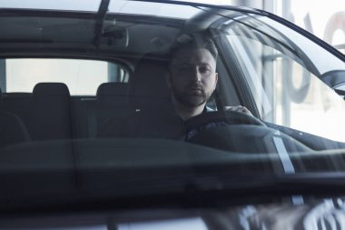 - İşe gidiyorum. Lüks siyah arabasında oturan sakallı genç işadamının ön görüntüsü..