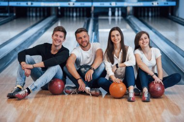 Birlikte mutluyuz. Genç neşeli arkadaşlar hafta sonları bowling kulübünde eğleniyorlar..