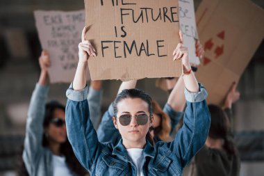 Güneş gözlükleriyle zemin yansıması. Bir grup feminist kadın dışarıda hakları için protesto yapıyor..