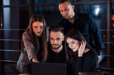 Dikkatini buna ver. Genç iş adamlarından oluşan bir ekip gece ofiste projeleri üzerinde çalışıyor..