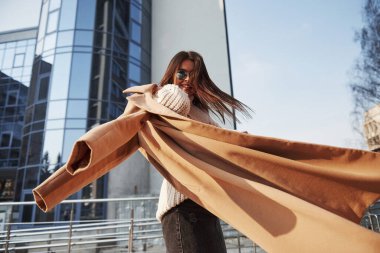 Kendi etrafında dönüyor. Kalın elbiseli genç bir kız hafta sonları şehirde yürür..