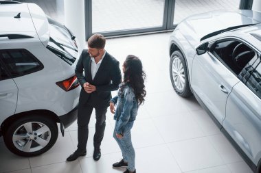 Sıradan giyinmiş bir kız. Kadın müşteri ve modern stil sahibi sakallı iş adamı otomobil barında..