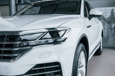 Yepyeni bir araba. Gündüz vakti park edilmiş modern lüks beyaz arabanın parçacık görüntüsü.