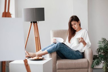 Planı okuyorum. Beyaz duvarları ve pencereden gelen gün ışığıyla odada genç bir esmer..