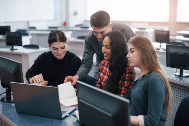 Modern ofiste çalışan günlük kıyafetli bir grup genç..