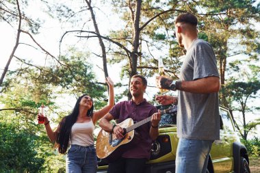 Birlikte şarkılar söylüyoruz. Arkadaşlarının hafta sonları akustik gitarlı yeşil arabalarının yanında güzel bir hafta sonu geçirirler..