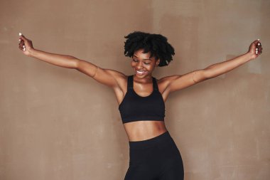 Yeni bir gün geldi. Stüdyodaki güzel Afro-Amerikan kadın kahverengi arka plana karşı..