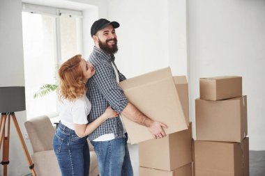 Yan görüş. Yeni evlerinde birlikte mutlu bir çift. Taşınma kavramı.