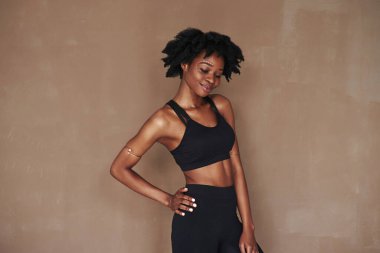 Keyfim yerinde. Stüdyodaki güzel Afro-Amerikan kadın kahverengi arka plana karşı..