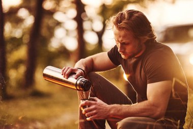 Taze ve sıcak içecek. Hafta sonu kamp ateşinin yanında siyah gömlekli bir adam vardı..