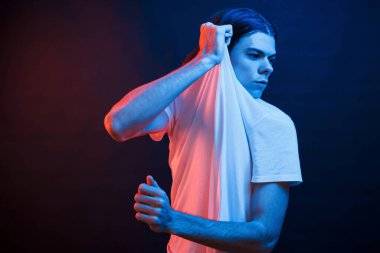 Esnetiyorum. Stüdyo karanlık stüdyoda neon ışıkla çekiliyor. Ciddi bir adamın portresi..