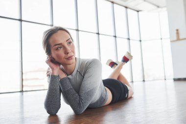 Dinlenme zamanı. Sportif genç bir kadın sabah spor salonunda spor yapıyor..