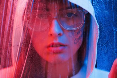 Islak kumaşa bakıyorum. Stüdyo karanlık stüdyoda neon ışıkla çekiliyor. Genç bir kızın portresi.