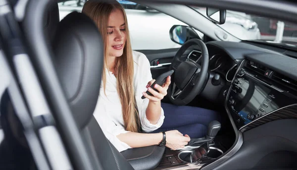 Kollar Meddelanden Telefon Vacker Blond Flicka Sitter Den Nya Bilen — Stockfoto