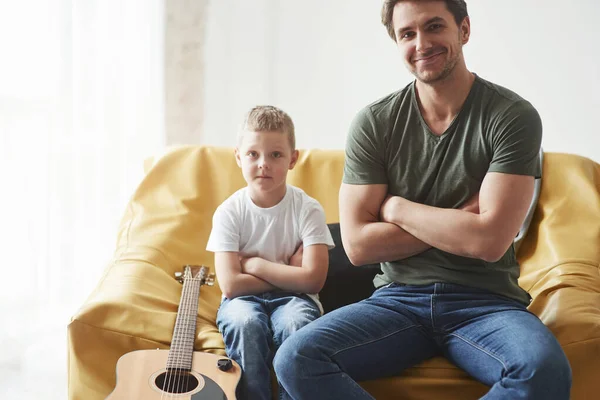 Πατέρας Και Γιος Του Κάθονται Στον Καναπέ Μαζί Ακουστική Κιθάρα — Φωτογραφία Αρχείου