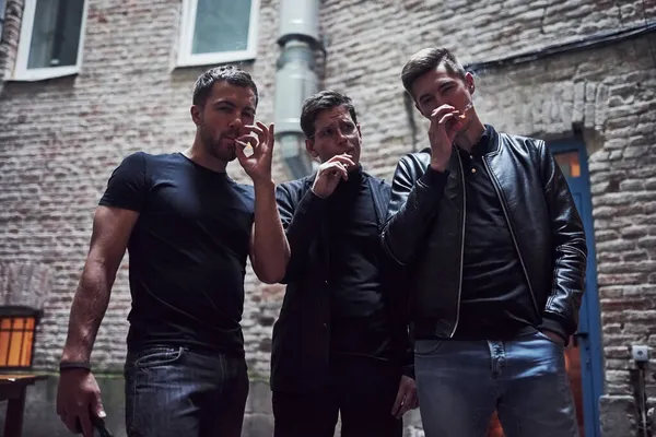 Καπνίζουμε Μαζί Τρεις Άντρες Φίλοι Στέκονται Έξω Από Μπαρ Συζητούσαμε — Φωτογραφία Αρχείου