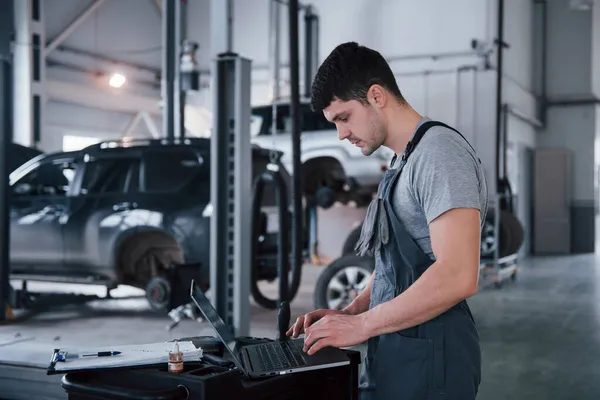 Seitenansicht Arbeiter Steht Uniform Drinnen Und Macht Berichte Berechnungen Und — Stockfoto