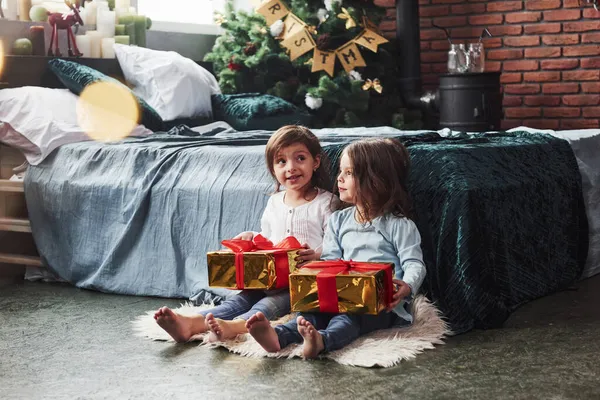 Искренние Эмоции Рождественские Праздники Подарками Двух Детей Которые Сидят Помещении — стоковое фото